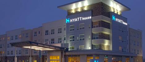 Een meerlaags hotel met een modern ontwerp, met een opvallend 'Hyatt House' bord op de gevel.