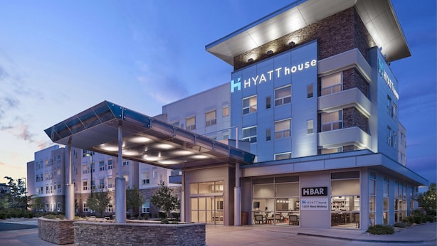 Un hotel a più piani dal design moderno, con ingresso coperto e un ristorante visibile chiamato HBAR.