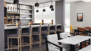 Zona bar moderna con scaffalatura per vini, sgabelli da bar e un'area salotto con tavoli e sedie.