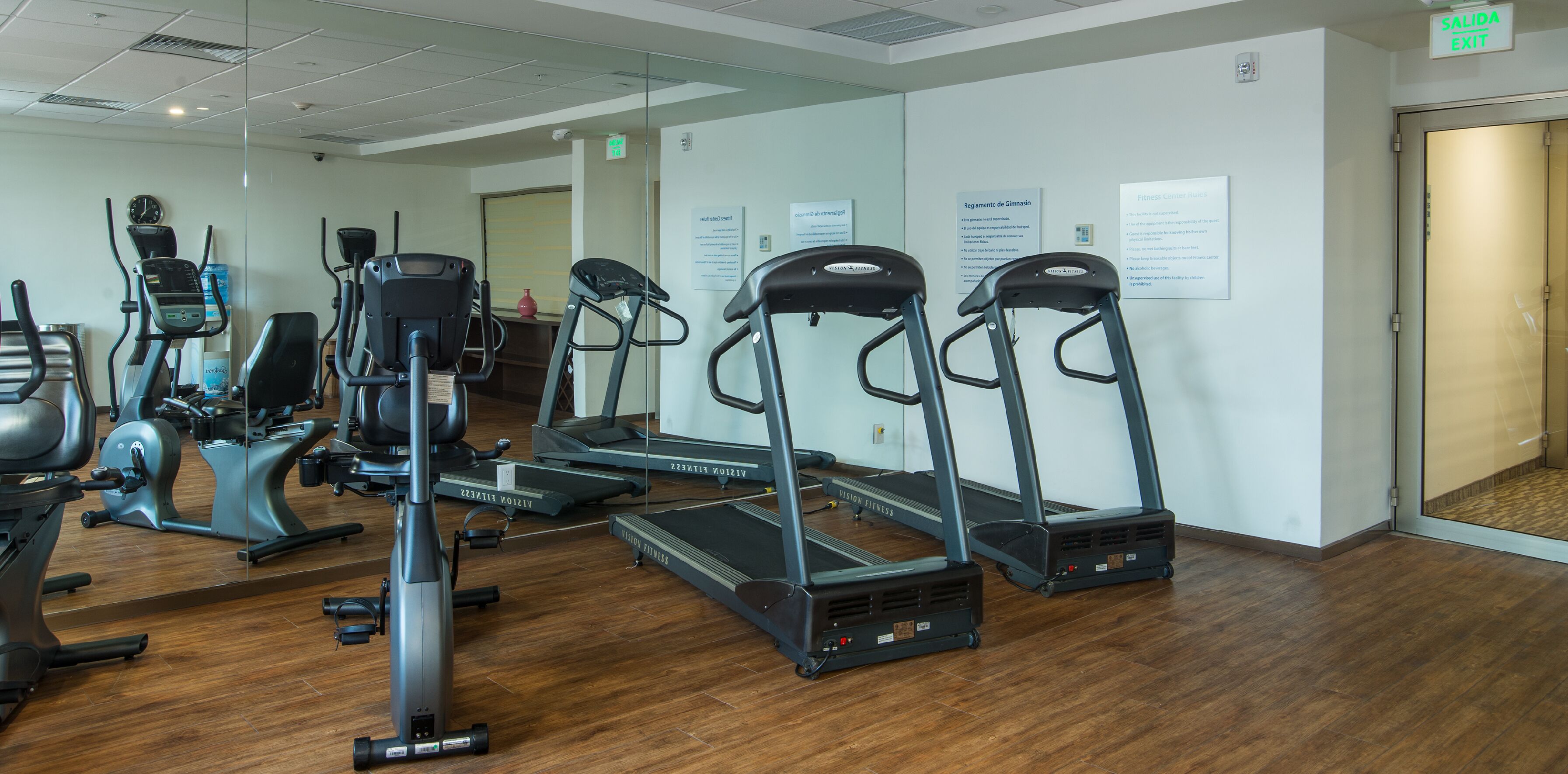 Un gimnasio con cintas de correr, elípticas y bicicletas estáticas.