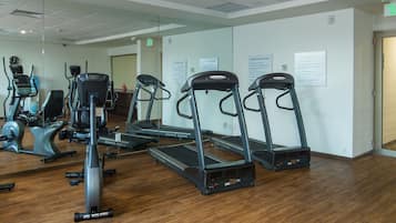 A gym with treadmills, elliptical machines, and stationary bikes.