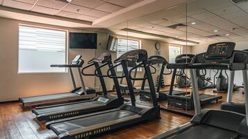 A gym with multiple treadmills, a stationary bike, and a rowing machine.