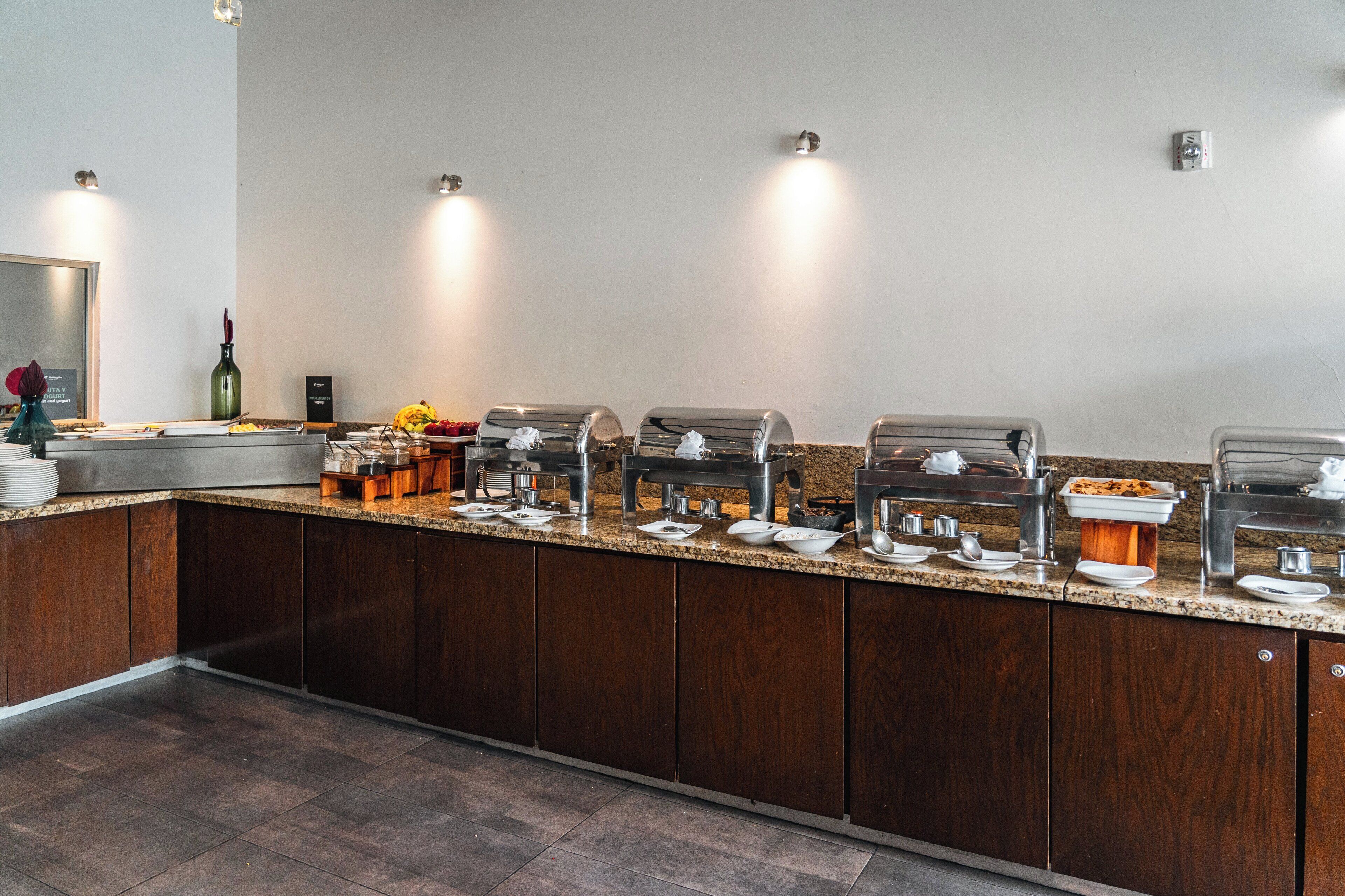 Un buffet composé de plusieurs présentoirs en libre-service, d’un comptoir en bois et d’un grand miroir placé à gauche.