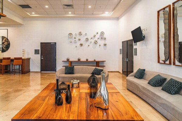 A modern living room with a wooden coffee table, sofas, and decorative wall art.