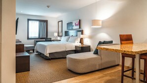 Una habitación de hotel con una cama, un sofá, una mesa de comedor y un escritorio.