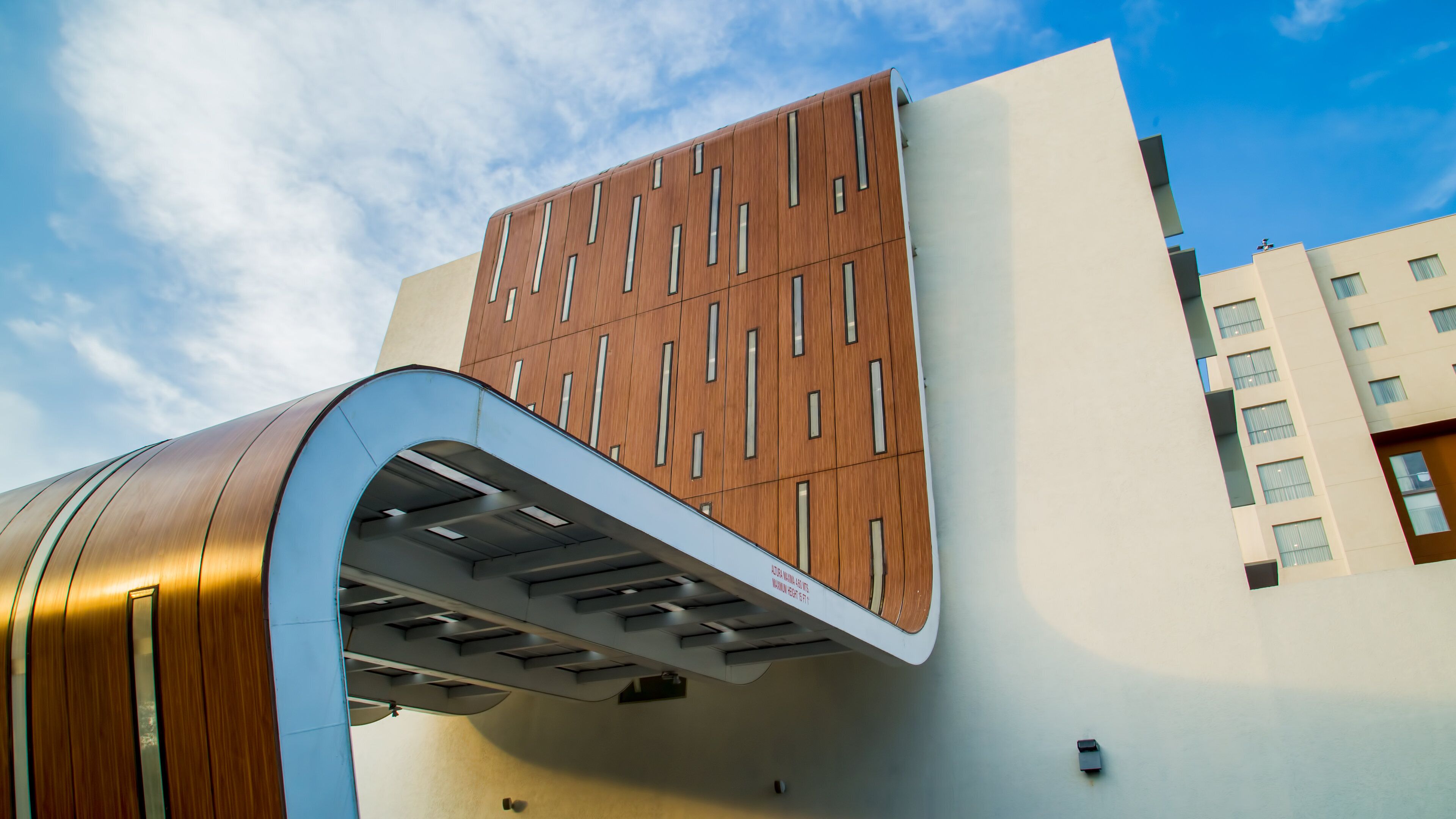 A modern building with a wooden facade and a curved entrance.