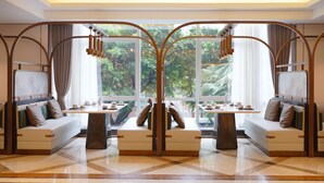 Una habitación de hotel moderna con un ventanal grande, un sofá, una mesa y una estructura de arco decorativa.
