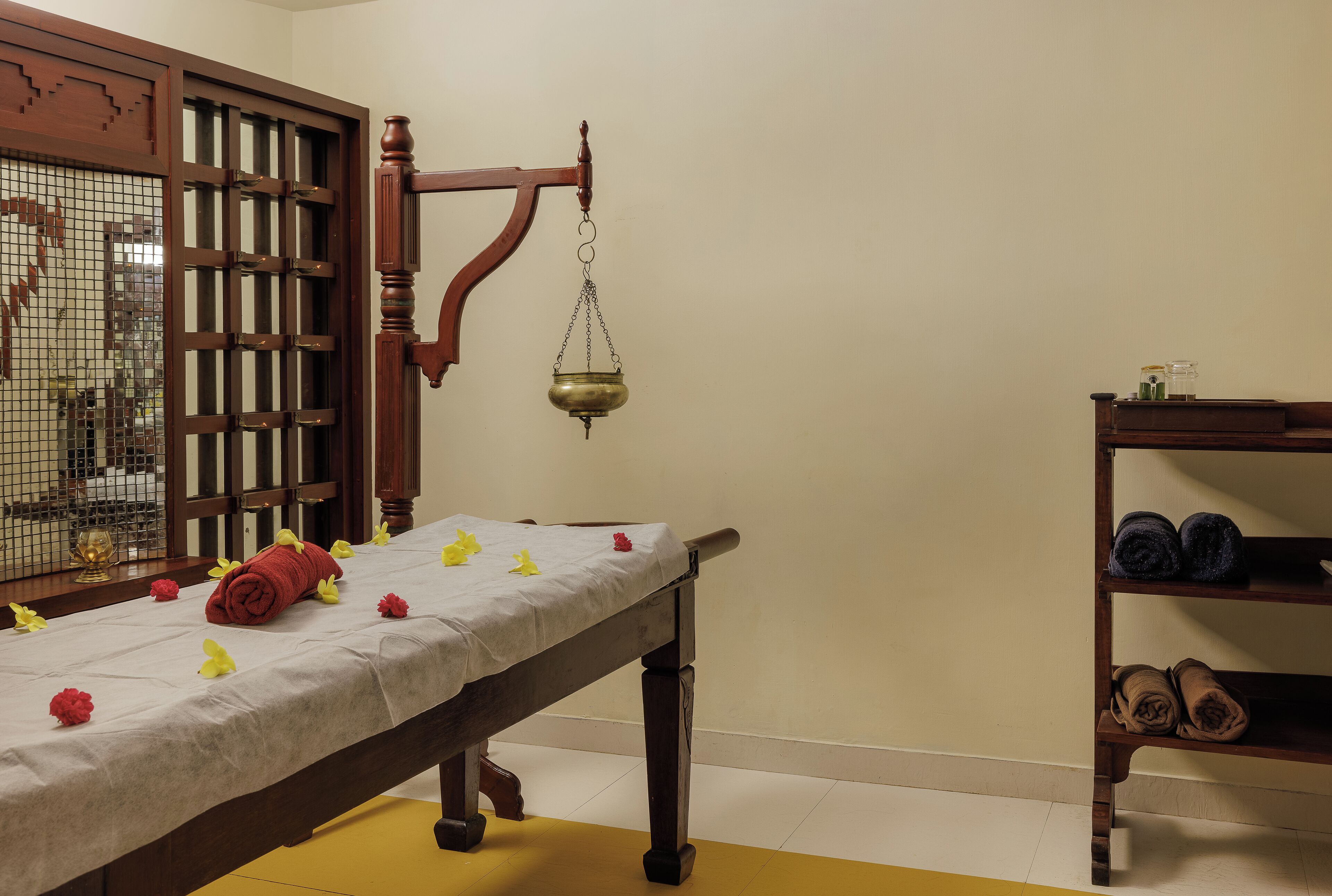 A room with a wooden bed, a scale, and a shelf with rolled-up mats.