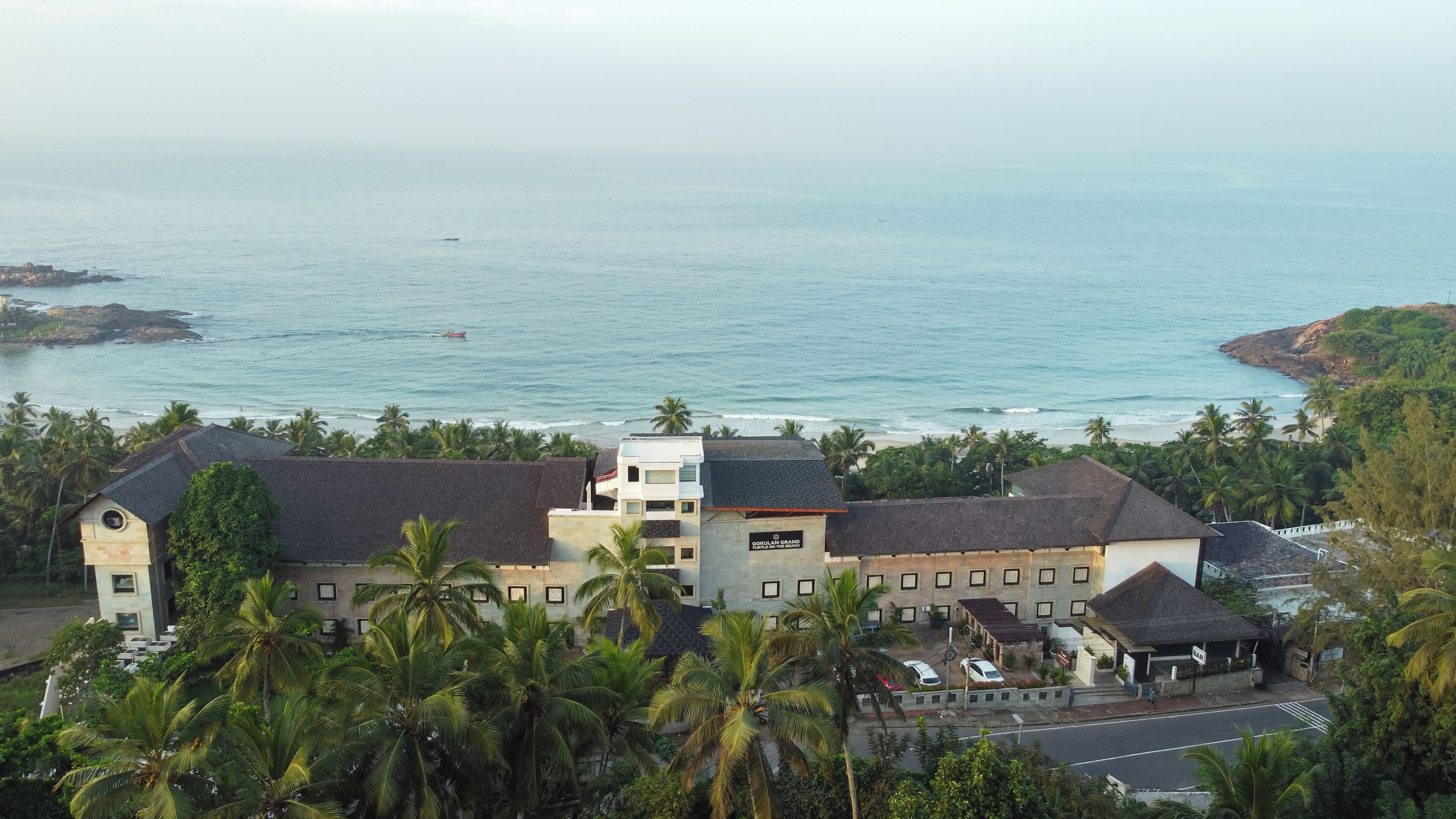 A coastal hotel with a prominent building labeled "Gokulam Grand Turtle of the Sea."