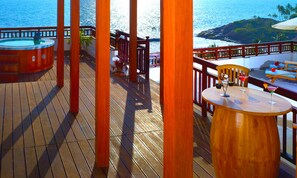 Relax on the ocean-view deck with two hot tubs and a table for unwinding.