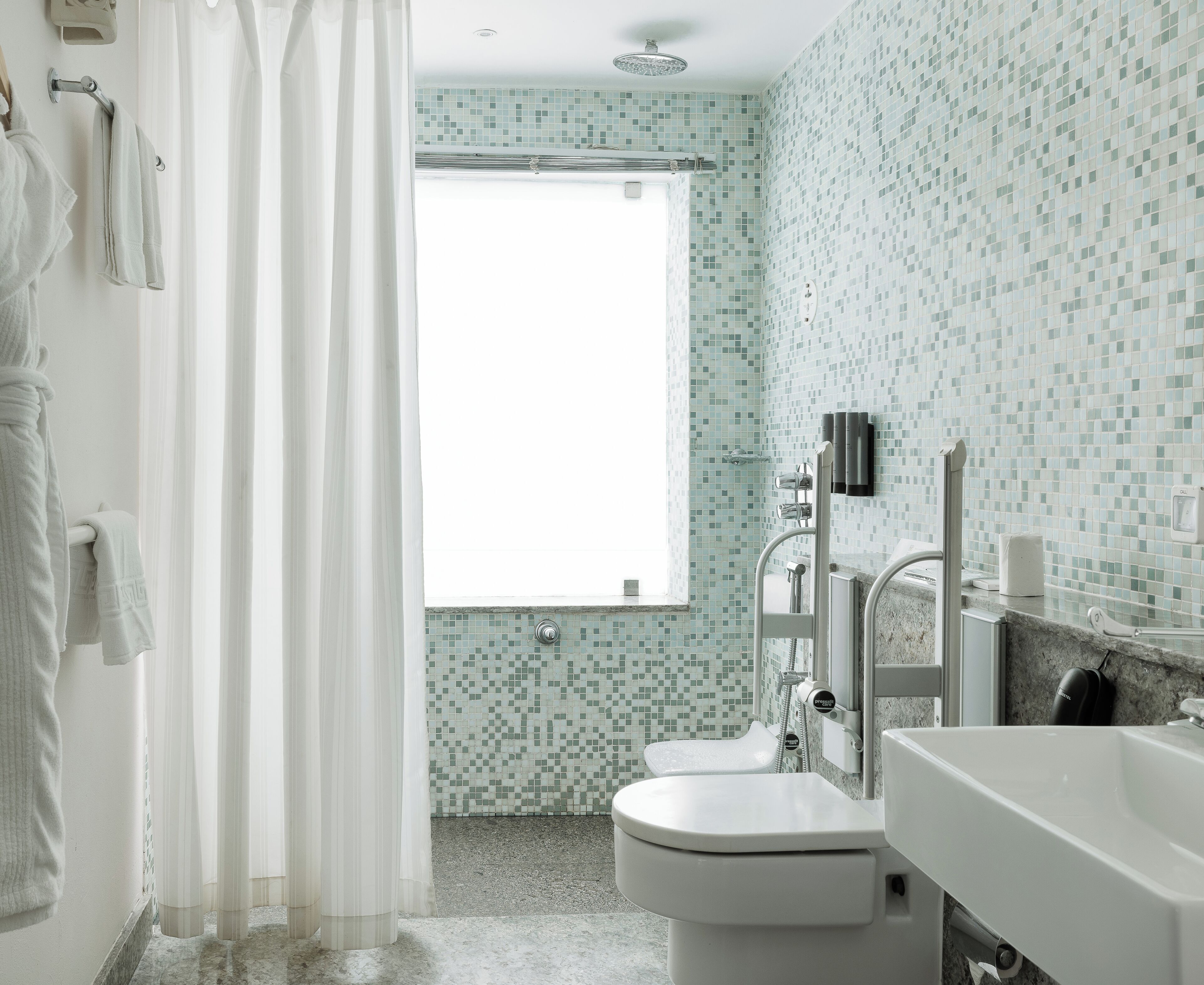 A bathroom with a toilet, sink, and shower area.