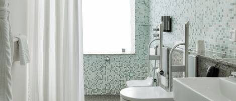 A bathroom with a toilet, sink, and shower area.