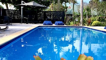 Een buitenzwembad en ligstoelen