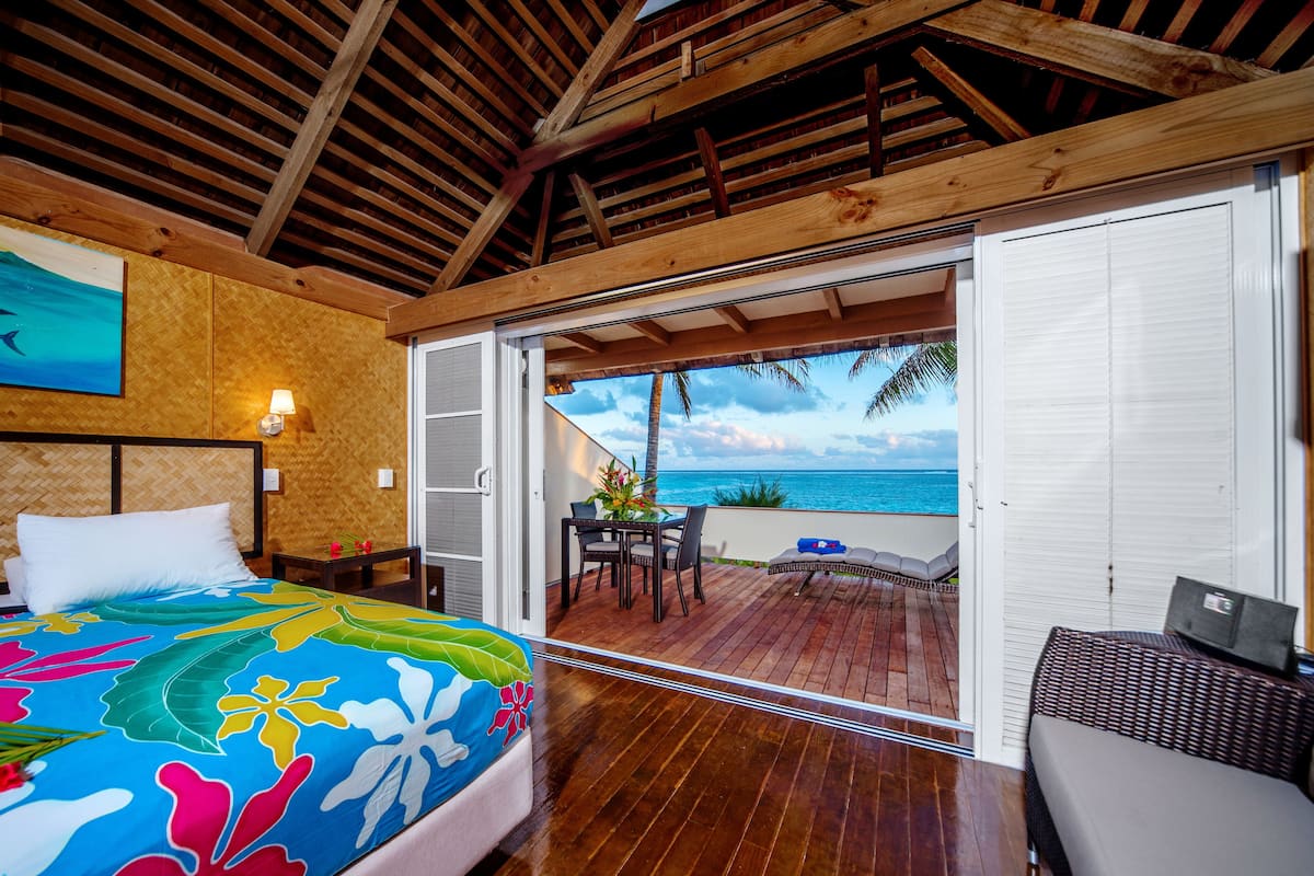Ein Schlafzimmer mit Bett, Nachttisch, Schreibtisch und Meerblick.