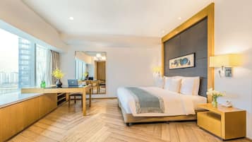 Ett modernt hotellrum med en stor säng, ett skrivbord och utsikt över staden.