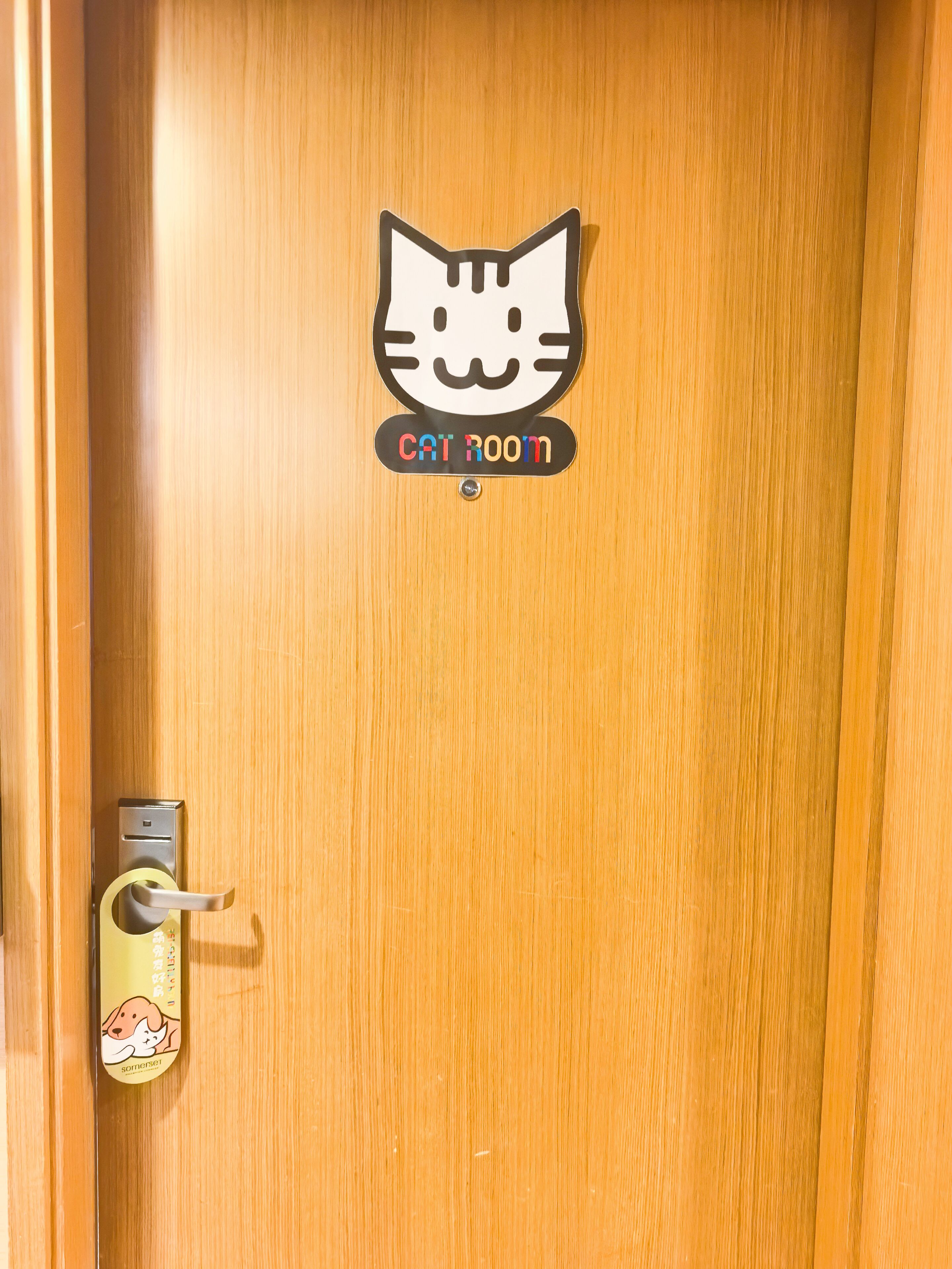 Une porte en bois ornée d’un autocollant représentant un chat et un carillon décoré d’un autocollant représentant un chien.