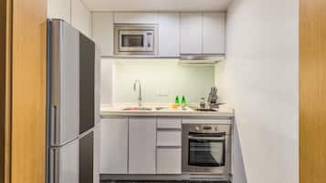 Una cocina compacta equipada con microondas, horno y lavavajillas integrados.