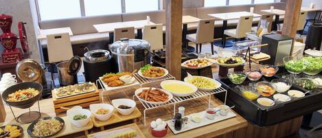 A buffet setup with various dishes and condiments.