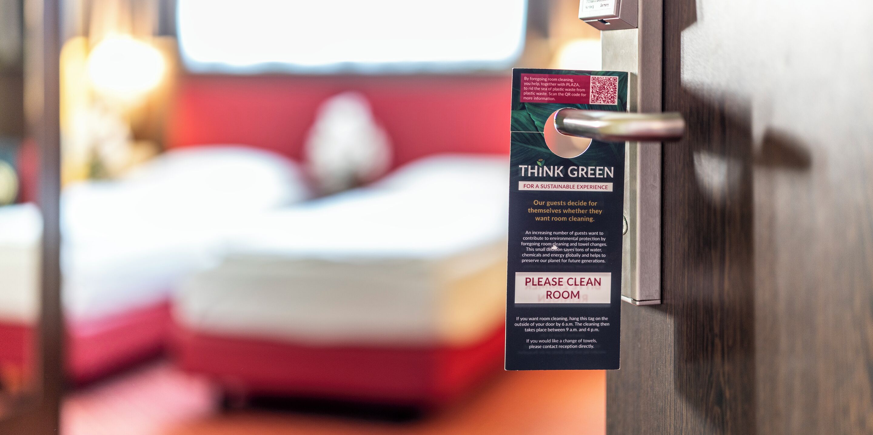 A hotel room door with a sign that reads "THINK GREEN FOR A SUSTAINABLE EXPERIENCE" and "PLEASE CLEAN ROOM".
