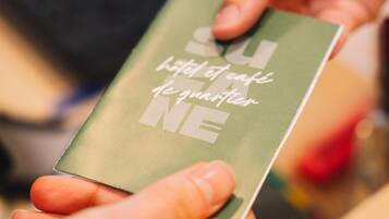 A person holding a green booklet with text on it.