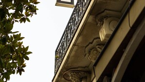 A hotel sign with ornate metalwork and a balcony.