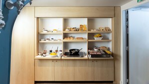 A modern kitchen with wooden cabinets and shelves displaying various food items and kitchenware.