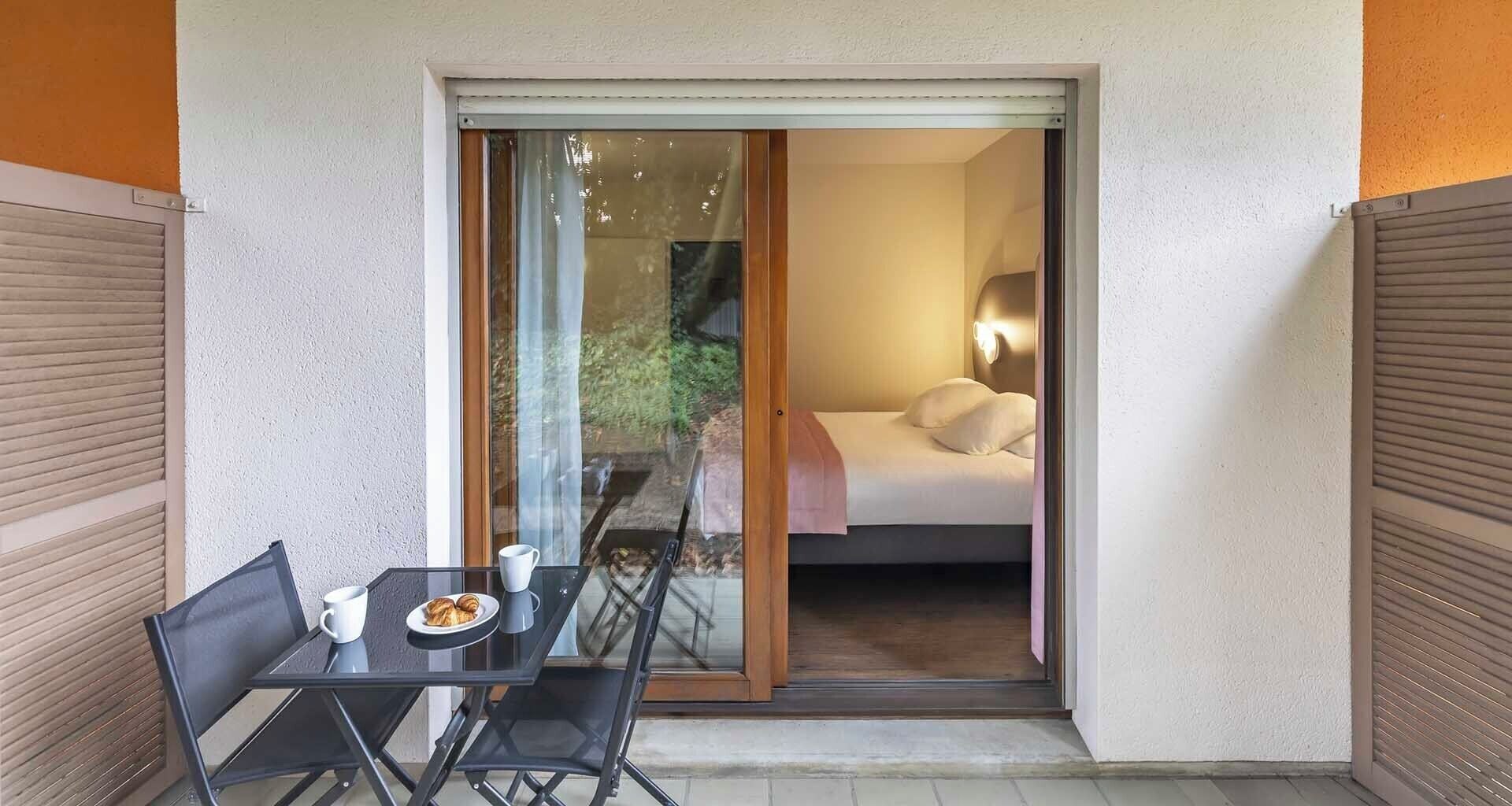 Ein Balkon mit Tisch, Stühlen und einer Frühstücksecke.