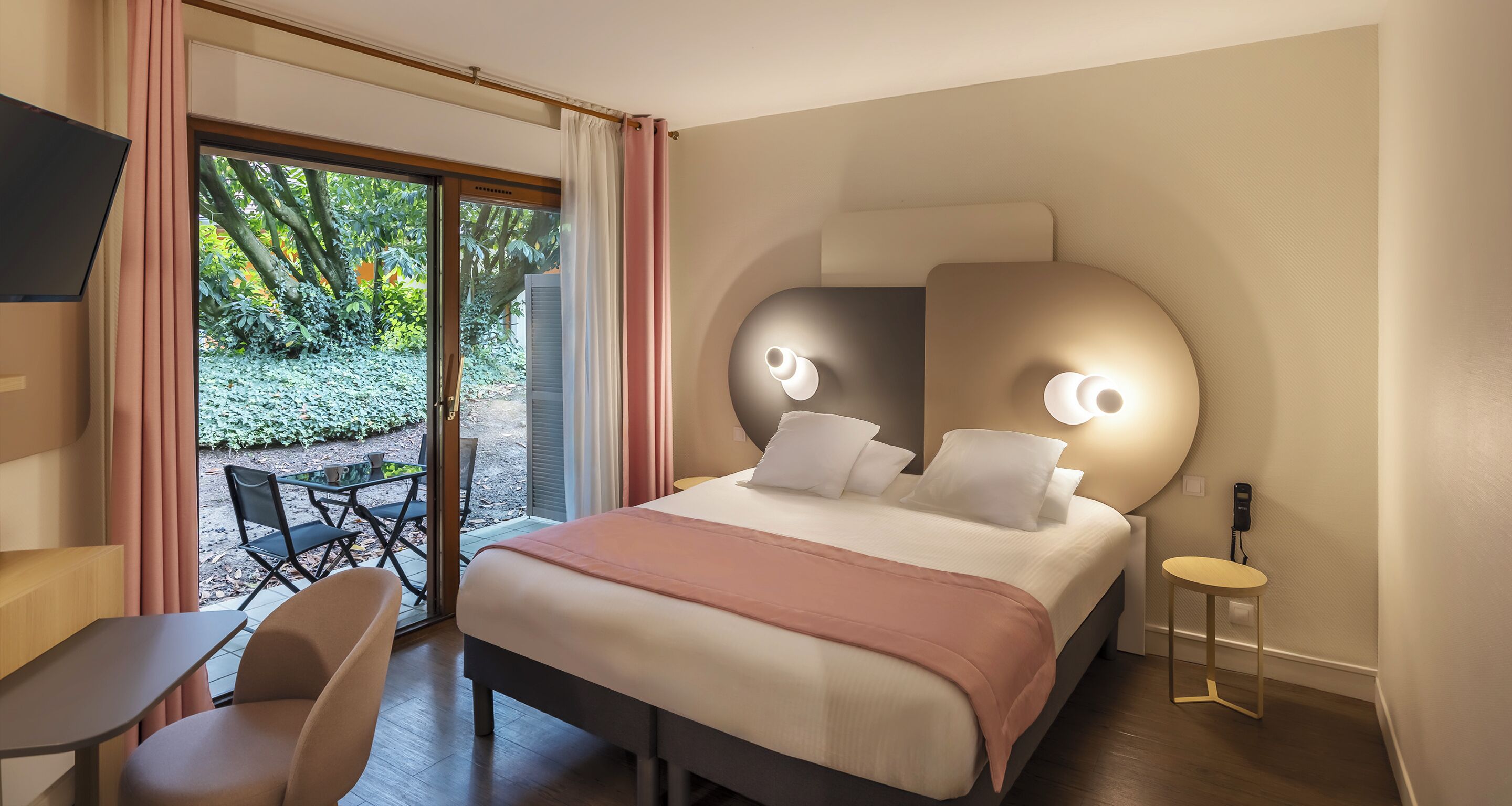 A modern hotel room with a large bed, a desk, and a chair.