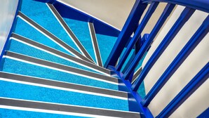 A staircase with blue steps and white stripes, leading upwards.