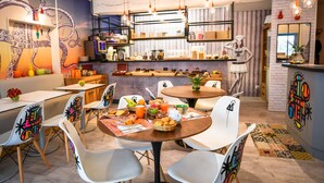 A modern dining area with tables, chairs, and a variety of breakfast items.