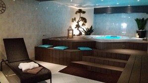 A spa area with a hot tub, wooden seating, and a relaxation chair.