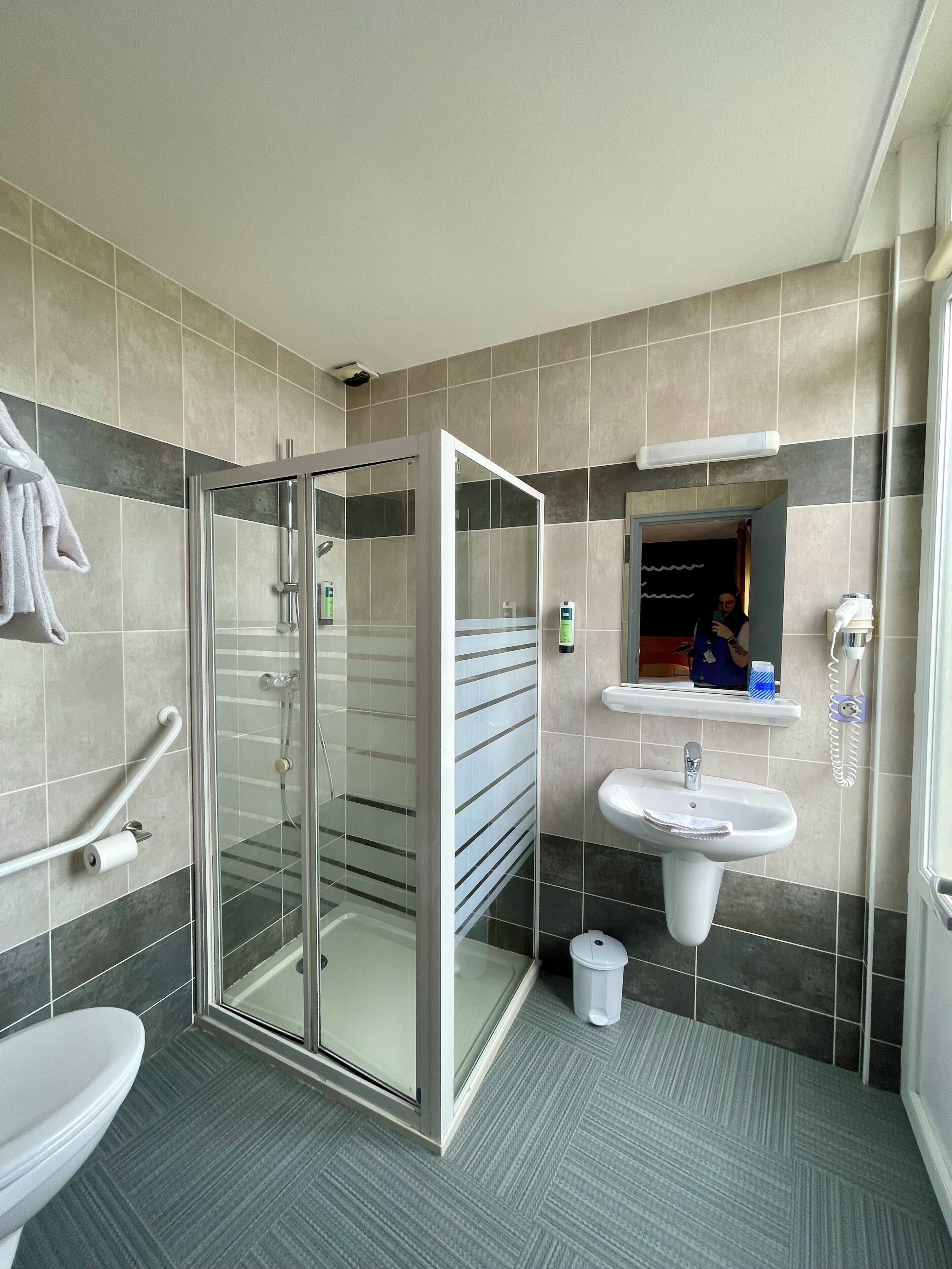 Une salle de bain moderne avec une douche à parois de verre, un lavabo et des toilettes.