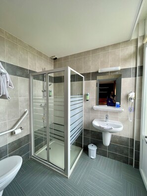 A modern bathroom with a glass shower enclosure, a sink, and a toilet. - Cit'Hotel La Marinière (Saint-Malo)
