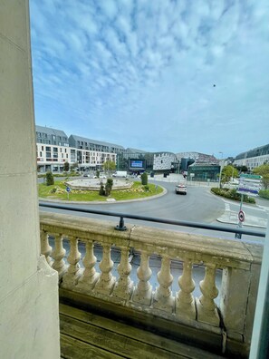 A modern building with a glass facade, a roundabout with a traffic island, and a clear sky. - Cit'Hotel La Marinière (Saint-Malo)