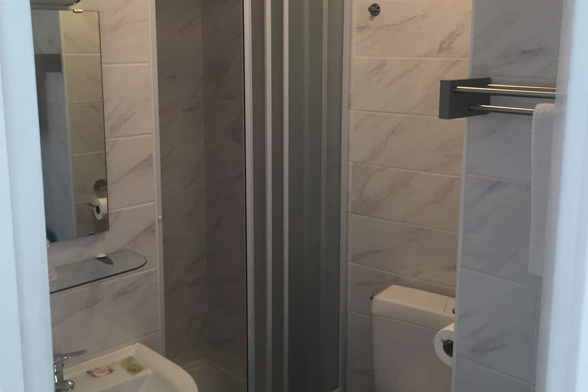 A bathroom with a shower, toilet, and sink.