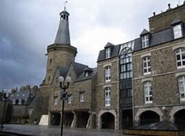 A historic building with a prominent tower and arched windows.