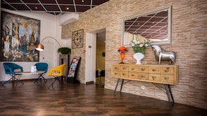 Ein modernes Interieur mit einer Holzwand, einem großen Gemälde, einer Holzkabine und zwei Stühlen.