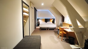 A compact hotel room with a bed, a desk, and a chair. - Citotel De Harlay (Compiègne)