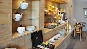 A breakfast buffet with tea sets, plates, and a variety of food items. - Citotel De Harlay (Compiègne)