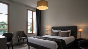 A hotel room with a large bed, two bedside lamps, a chair, and a desk. - Hôtel du Moulin, Niort (Niort)