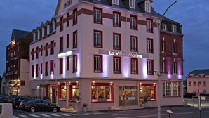 Ein mehrstöckiges Gebäude mit der Beschilderung 'La Villa Marine', mit Restaurant und mehreren Balkonen.