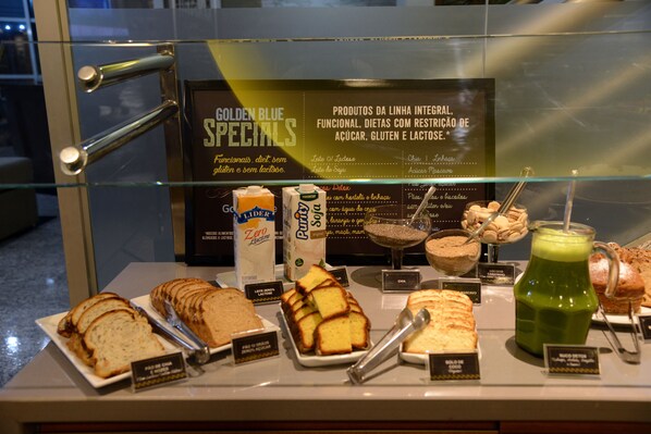 A display of breakfast items including bread, yogurt, and a green smoothie.