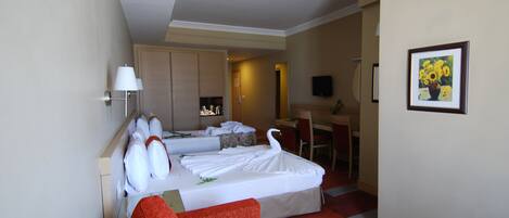 Habitación de hotel con cama, escritorio, silla y sofá rojo.