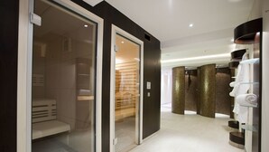 A modern hotel bathroom with a walk-in shower, glass shelves with towels, and a wooden bench. - Hotel Gräfrather Hof (Solingen)