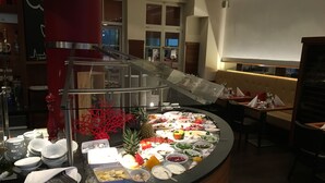 A buffet setup with various food items and utensils. - Hotel Gräfrather Hof (Solingen)