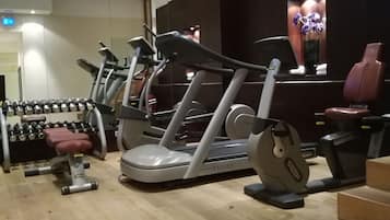 A gym with treadmills, dumbbells, and a rowing machine.
