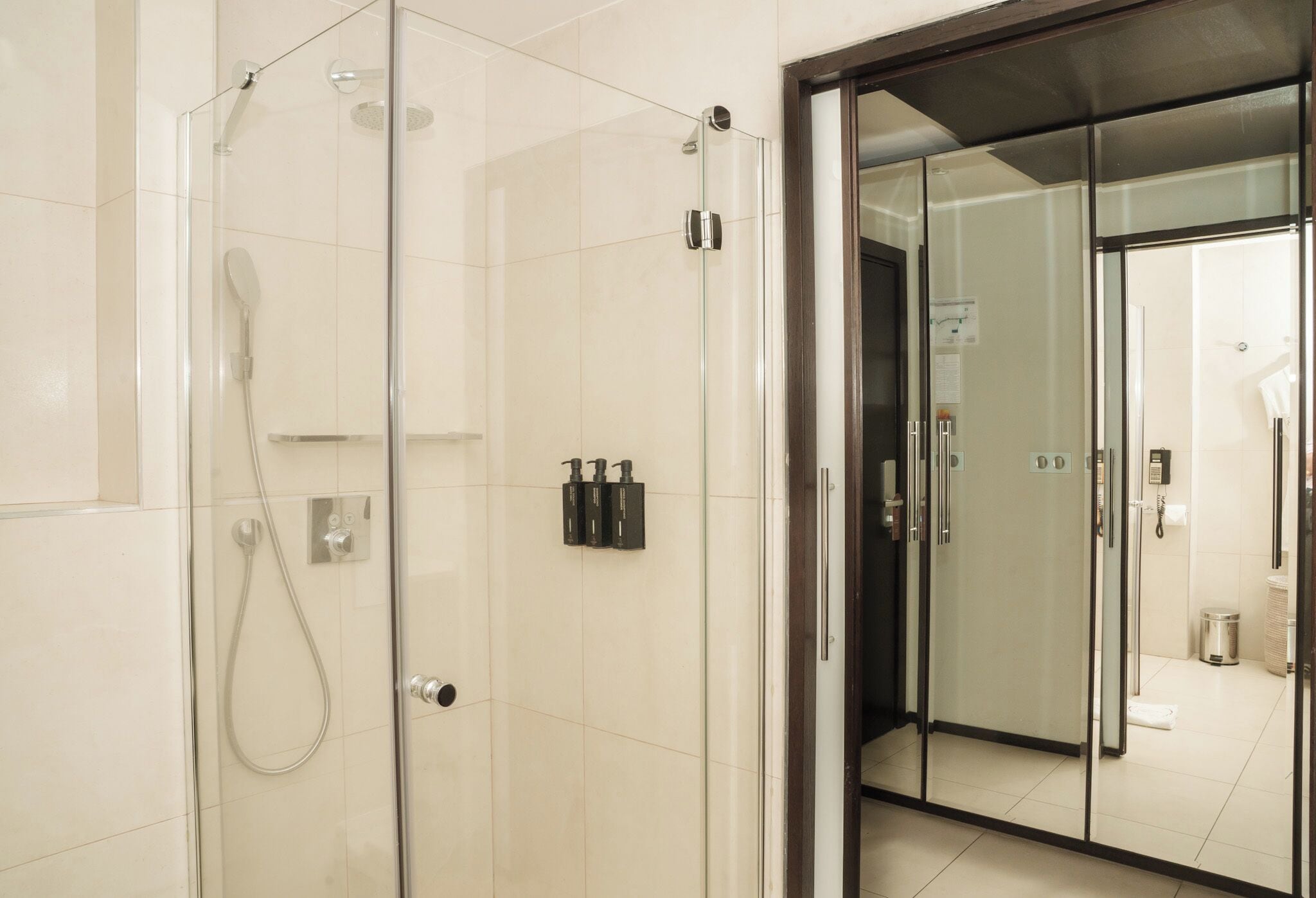 A modern bathroom with a glass-enclosed shower, a toilet, and a sink.