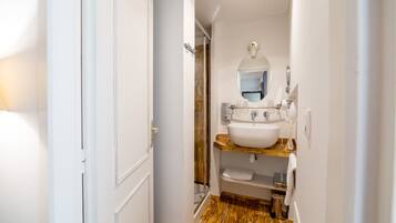 A compact bathroom with a white sink, mirror, and towel rack.