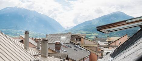 A view of a town with buildings and a mountain in the background.