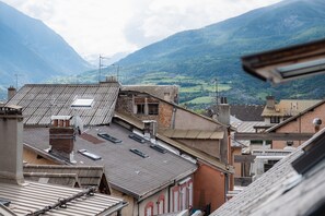 Une vue d’un paysage montagneux, avec des bâtiments au premier plan.